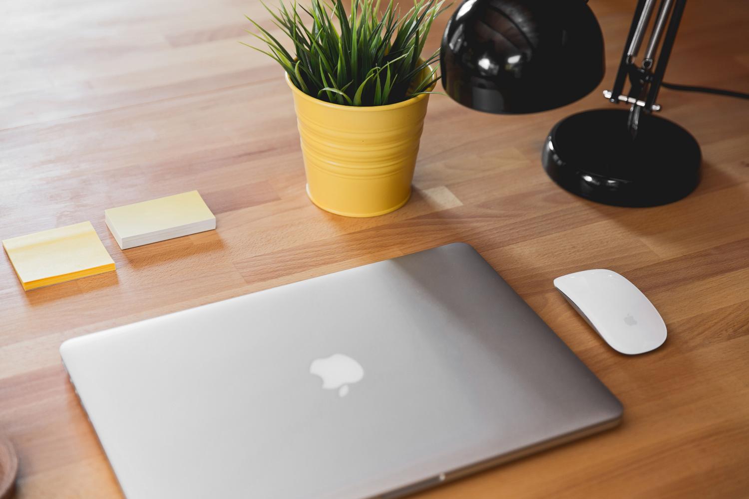 MacBook cerrado en un escritorio profesional y minimalista con accesorios de oficina.
